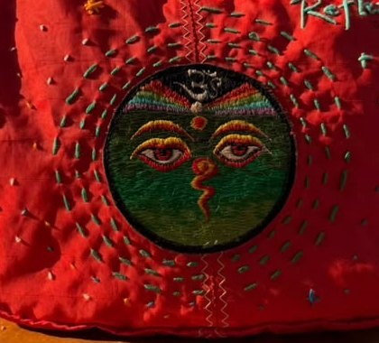 Close-up of hand embroidery on the red shoulder bag